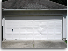 Dented garage door. This door is only construction grade (26G) and would eventually look like the open door above if not replaced with a professional grade door.